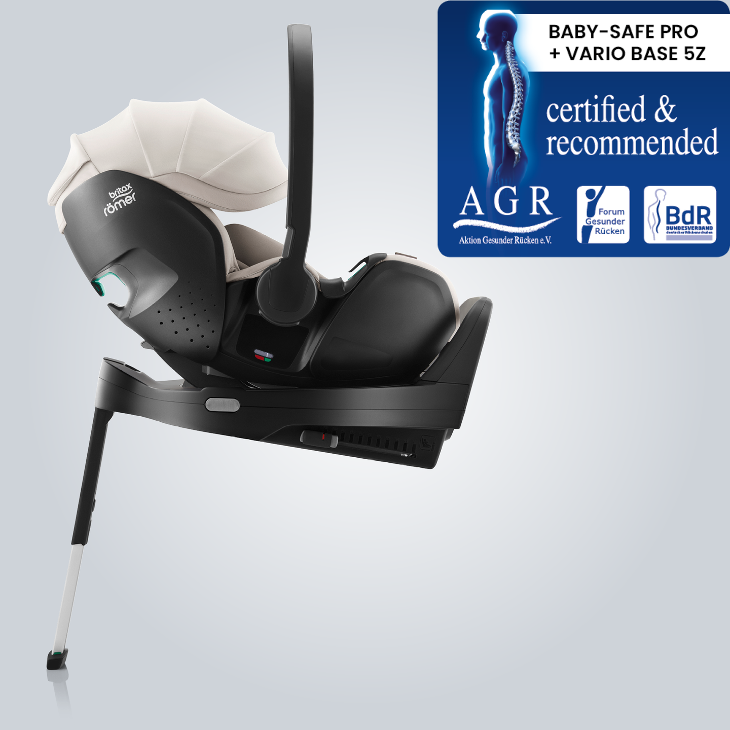 BABY-SAFE PRO babyskydd i Soft Taupe, monterat p&aring; en ISOFIX-bas med st&ouml;dben, visat i sidovy med Aktion Gesunder R&uuml;cken e.V. &rdquo;Tested & Recommended&rdquo;-m&auml;rkningen.